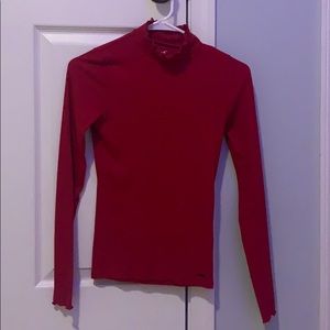 Red turtle neck, ruffles around the neck/sleeves